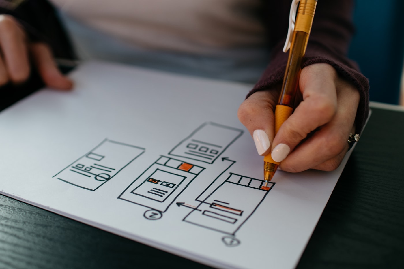 Designer reviewing website layouts and page structure on a laptop