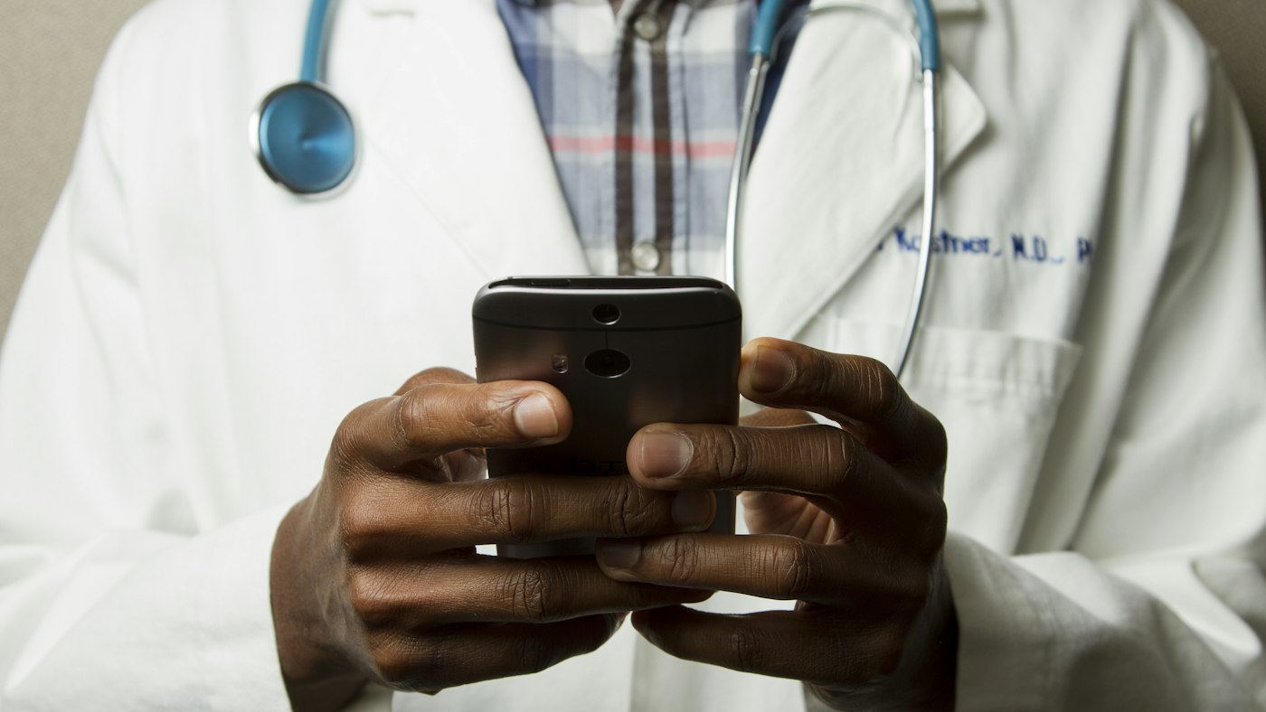 Clinician reading a phone — Dubai sites have to remain clear for people of every age and vision